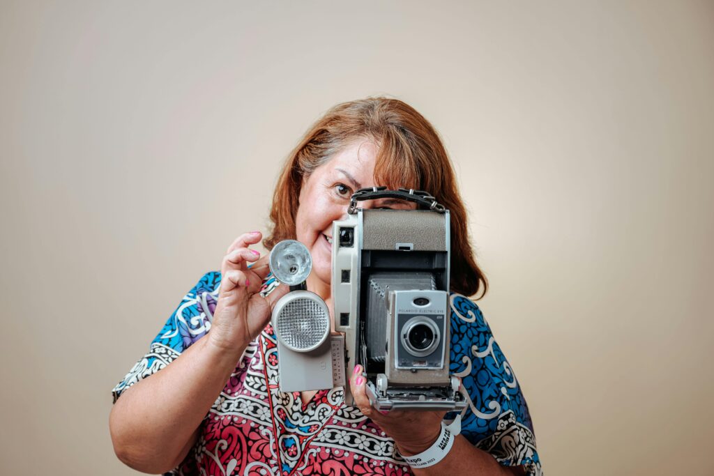 Photo of a Woman with a Retro Camera on a Beige Background