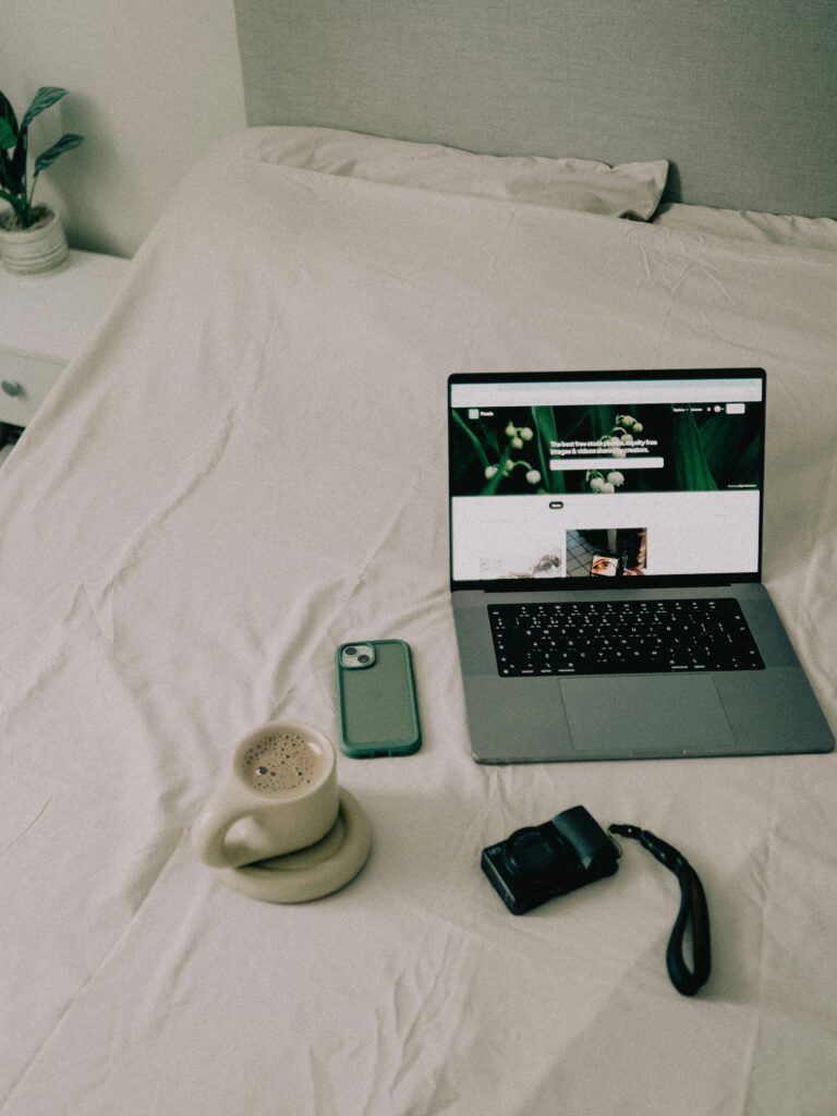 A Coffee and Electronics Standing on the Bed