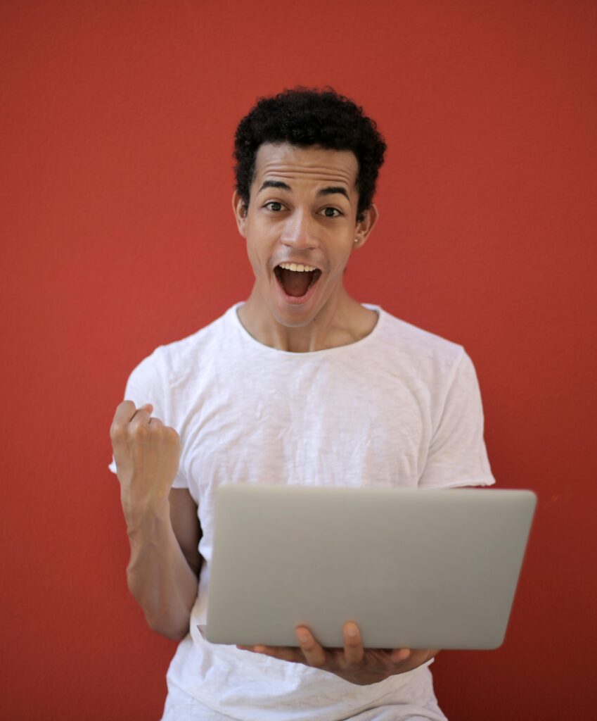 Man in White Crew Neck T-shirt Holding Laptop