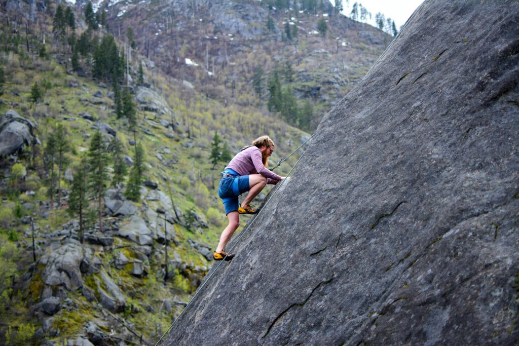 Man Climbing on Rock Mountain