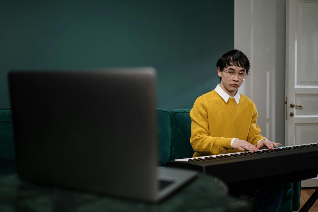 Man in Yellow Sweater Sitting on a Green Sofa