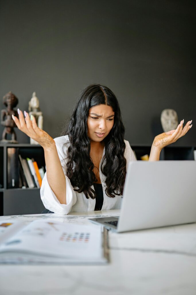 A Confused Woman Looking at her Laptop